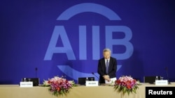 President of Asian Infrastructure Investment Bank (AIIB) Jin Liqun greets to journalists as he arrives at a news conference in Beijing, Jan. 17, 2016.