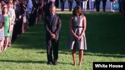 FILE - President Barack Obama, first lady Michelle Obama and White House staff hold moment of silence in honor of 9/11 attack victims, Sept. 11, 2015.