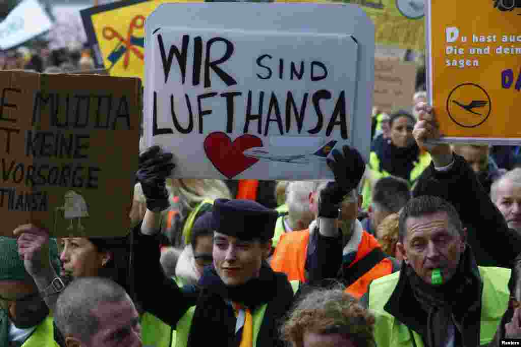 A Lufthansa employee holds up a placard reading &#39;we are Lufthansa&#39; during a strike by cabin crew union at Frankfurt airport, Germany. Lufthansa has promised a return to normal flight schedules on Saturday. The week-long strike was expected to ground another 941 flights on Friday.