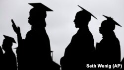 FILE- In this May 17, 2018, file photo, new graduates line up before the start of the Bergen Community College commencement at MetLife Stadium in East Rutherford, New Jersey.