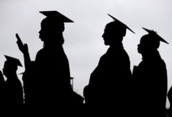 FILE- In this May 17, 2018, file photo, new graduates line up before the start of the Bergen Community College commencement at MetLife Stadium in East Rutherford, New Jersey.