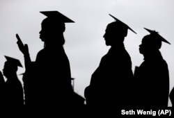 FILE- In this May 17, 2018, file photo, new graduates line up before the start of the Bergen Community College commencement at MetLife Stadium in East Rutherford, New Jersey. (AP Photo/Seth Wenig, File)