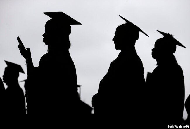 FILE- In this May 17, 2018, file photo, new graduates line up before the start of the Bergen Community College commencement at MetLife Stadium in East Rutherford, New Jersey. (AP Photo/Seth Wenig, File)