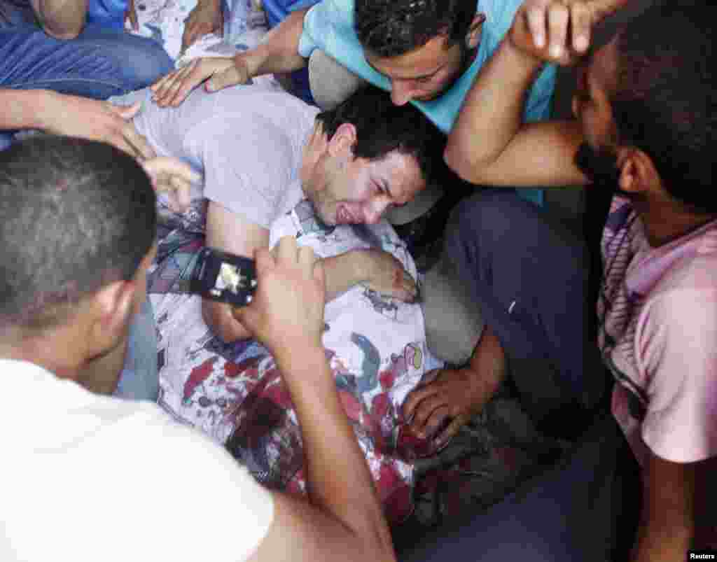 Supporters of former Egyptian President Mohamed Morsi gather around the covered body of a victim of clashes outside the Republican Guard building in Cairo, July 5, 2013.&nbsp;