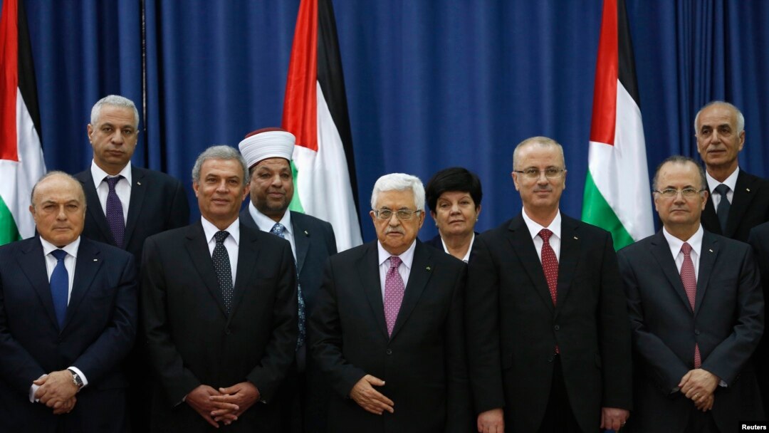 PM Palestina Rami Hamdallah (ke-4 dari kiri) dan Presiden Mahmoud Abbas berpose bersama para Menteri pemerintah persatuan Palestina yang baru dilantik di Ramalllah, Senin (2/6).