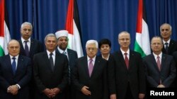 PM Palestina Rami Hamdallah (ke-4 dari kiri) dan Presiden Mahmoud Abbas berpose bersama para Menteri pemerintah persatuan Palestina yang baru dilantik di Ramalllah, Senin (2/6).