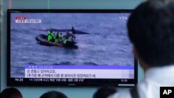 Orang-orang menonton berita penjaga pantai Korea Selatan mencari penumpang yang hilang setelah sebuah kapal nelayan tenggelam di pulau resor Jeju, di stasiun kereta api Seoul di Seoul, Korea Selatan, Minggu, 6 September 2015