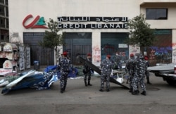 FILE - Lebanese security forces remove tents as they clear away a protest camp and reopen roads blocked by demonstrators since protests against the governing elite started in October, in Beirut, Lebanon, March 28, 2020.