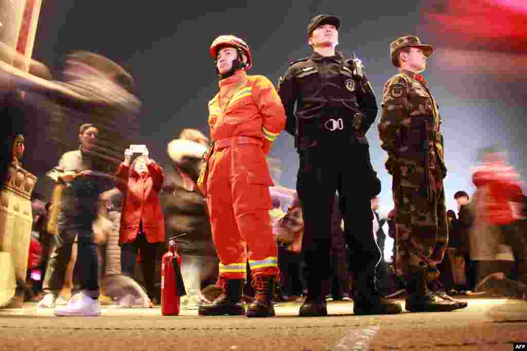 2018年2月28日，中国消防员（左）、警察（中）和武警在南京元宵节前的灯会上站岗。