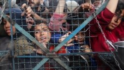 Palestinians line up to receive free meals at Jabaliya refugee camp in the Gaza Strip on March 18, 2024.