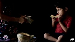 Ardawan, 4, eats melon on the kitchen floor of an orphanage for Yazidi children in Sheikhan, Iraq. Aug. 22, 2108.