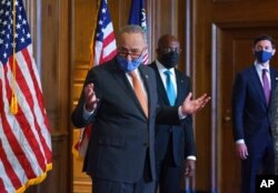 On the first full day of the Democratic majority in the Senate, Majority Leader Chuck Schumer, D-N.Y., left, is joined by Sen. Raphael Warnock, D-Ga., center, and Sen. Jon Ossoff, D-Ga., during a press event at the Capitol, Jan. 21, 2021.