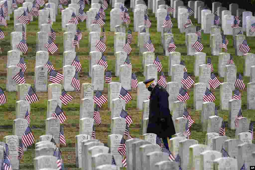 Retired U.S.Army veteran Bill MacCully walks among flag-covered graves in the Veterans Cemetery of Evergreen Washelli Memorial Park on Veterans Day in Seattle, Washington.