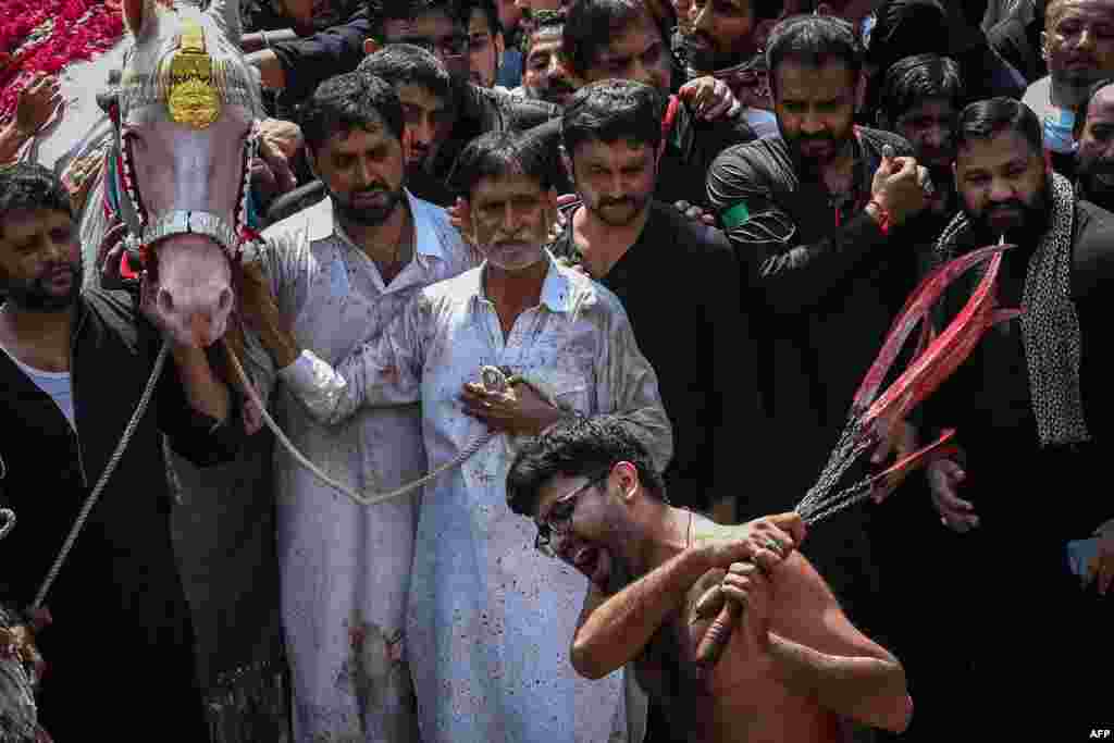 파키스탄 라호르에서 이슬람력 첫 달인 &#39;무하람&#39;을 맞아 시아파 순례자들이 스스로를 때리며 고통을 감내하는 의식을 하고 있다.