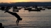 Un hombre se lanza desde un muelle al atardecer en Tongoy, Chile, el martes 21 de enero de 2025. 