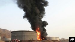 Firefighters work to extinguish a fire following rocket attacks by Shiite rebels known as Houthis at storage tanks of an oil refinery in the port city of Aden, Yemen, July 14, 2015. 