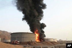 Firefighters work to extinguish a fire following rocket attacks by Shiite rebels known as Houthis at storage tanks of an oil refinery in the port city of Aden, Yemen, July 14, 2015.