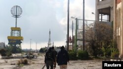 Rebel fighters walk around al-Hamidiyeh base, one of two military posts they took control of from forces loyal to Syria's President Bashar al-Assad in the northwestern province of Idlib, Dec. 15, 2014. 