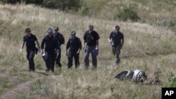 Australian experts examine the Malaysia Airlines Flight 17 crash site near Hrabove, Donetsk region, eastern Ukraine, Aug. 1, 2014. 