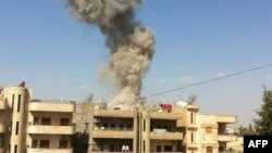 A handout picture released by the Syrian Arab News Agency (SANA) allegedly shows smoke rising as the state TV said a suicide car bomb rocked the Kurdish city of Qamishli, September 30, 2012.
