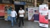 FILE - People walk past banners inviting students to study in Canada and other places abroad at a market in Amritsar, in the northern Indian state of Punjab, Oct. 15, 2024.