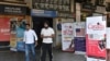 FILE - People walk past banners inviting students to study in Canada and other places abroad at a market in Amritsar, in the northern Indian state of Punjab, Oct. 15, 2024.