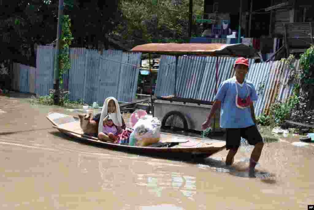 A man evacuates his family by boat from Ayutthaya, October 6, 2011. (VOA - D. Schearf)