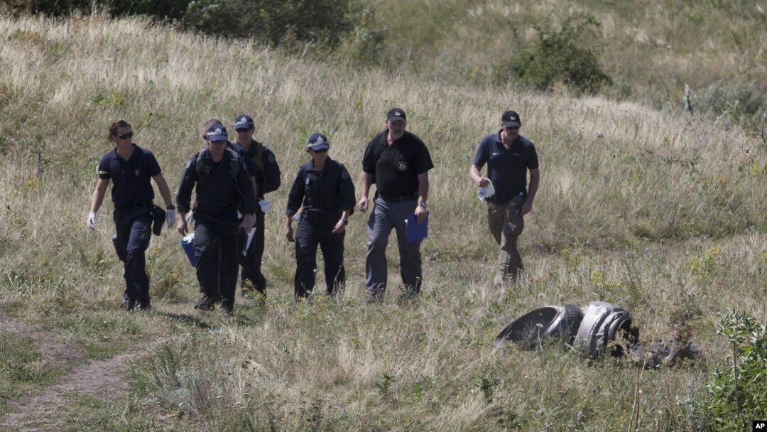 Australian experts examine the Malaysia Airlines Flight 17 crash site near Hrabove, Donetsk region, eastern Ukraine, Aug. 1, 2014. 
