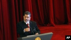 Presiden Mesir yang baru dilantik, Mohamed Morsi saat memberikan pidato pelantikan di Universitas Kairo, Mesir (30/6).