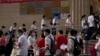 ARCHIVO - Estudiantes se forman para entrar a una escuela en el primer día de los exámenes de ingreso a la educación superior de China, conocido como el goakao, en Beijing, el martes 7 de junio de 2022.