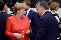 German Chancellor Angela Merkel, left, visits with Hungary's Prime Minister Viktor Orban at the NATO headquarters in Brussels, May 25, 2017.