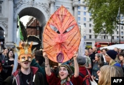 Activists sing songs at the Extinction Rebellion group's environmental protest camp at Marble Arch in London, April 25, 2019, during the group's protest calling for political change to combat climate change.