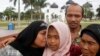 Jamaliah (L) kisses her daughter Raudhatul Jannah, 14, as the girl's father Septi Rangkuti and grandmother Sarwani look on following prayers at Baiturrahman mosque in Banda Aceh, Aug. 8, 2014. 