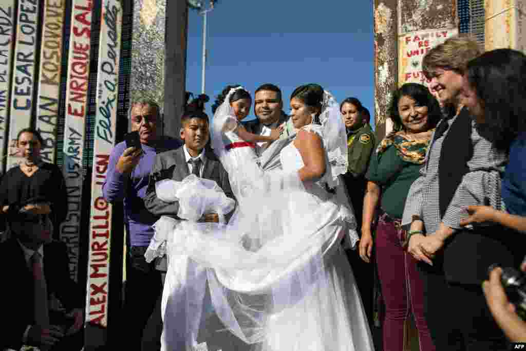 Bride Evelia Reyes and groom Brian Houston, living on different sides of the U.S.-Mexico border, stand for a family portrait after getting married during the &quot;Opening the Door of Hope&quot; event at the border fence gate in Playas de Tijuana, Mexico, Nov. 18, 2017