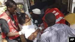 A woman injured in a grenade attack at the Utawala Inter-denominational church is helped into ambulance in Garissa, northern Kenya, November 4, 2012. 