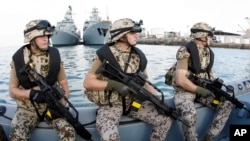 FILE - German special forces are seen on a speed boat in front of the German frigates Karlsruhe, left, and Mecklenburg-Vorpommern in Djibouti, Dec. 23, 2008.
