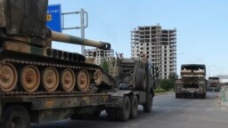 FILE - A convoy of Turkish military trucks is seen carrying tanks destined for Syria near the town of Kilis, Turkey, Sept. 14, 2018.