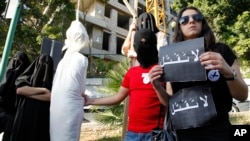 FILE - In this Thursday, April 1, 2010 file photo, activists from a civil organization reenact an execution scene in front of the Saudi Arabia Embassy in Beirut, Lebanon, as they protest a possible beheading of a Lebanese man accused of witchcraft in Saudi Arabia.