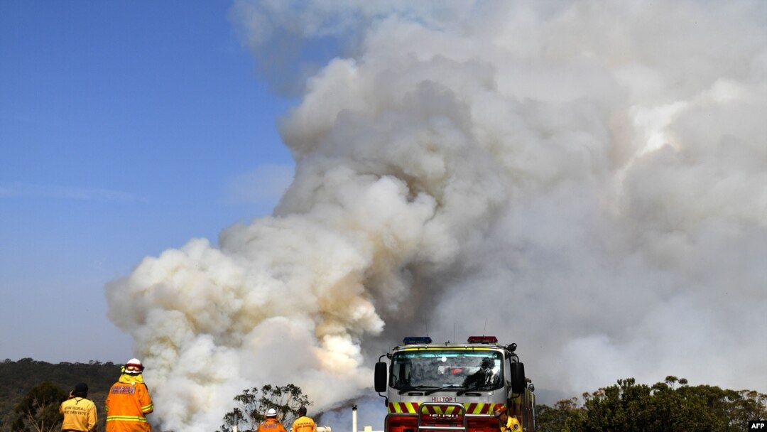 Firefighters work as smoke rises from a bushfire in Penrose, New South Wales, Australia, Jan. 10, 2020. High temperatures and strong winds were expected to fan massive bushfires blazing across southeastern Australia after several days of reprieve.