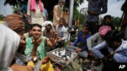 Supporters of the Dera Sacha Sauda sect charge their mobile phones as they squat in a public park near an Indian court in Panchkula, India, Aug. 24, 2017.