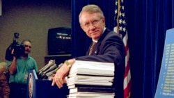 FILE - Sen. Harry Reid, D-Nev., leans on a stack of documents pertaining to campaign finance reform during a Capitol Hill news conference on Dec. 3, 1996