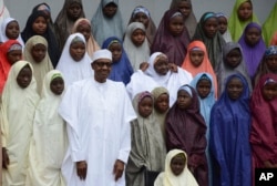 FILE - Nigeria President, Muhammadu Buhari (C), poses for a photograph with recently freed School girls from the Government Girls Science and Technical College Dapchi, by at the Presidential palace in Abuja, Nigeria, March 23, 2018.