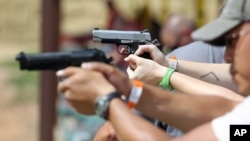 A judge overturned a prohibition on handguns in Washington, D.C., and the city is considering an appeal. Here, shooters practice with pistols at a gun range near Colorado Springs, Colo., July 20, 2014. 