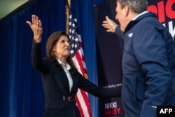FILE - Republican presidential candidate former UN Ambassador Nikki Haley (L) greets New Hampshire Governor Chris Sununu during a campaign event in Manchester, New Hampshire, on January 19, 2024.