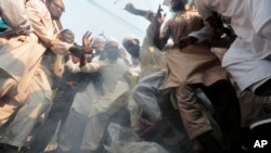 Bangladeshi activists of several Islamic political parties stomp on a burning effigy of Myanmar's Aung San Suu Kyi during a protest rally against the persecution of Rohingya Muslims in Myanmar, after Friday prayers in Dhaka, Bangladesh, Nov. 25, 2016.