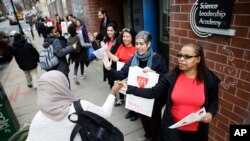 Maestro en Filadelfa saludan a sus alumnos mientras participan de la protesta "Un día sin mujeres" en el Día Internacional de la Mujer.