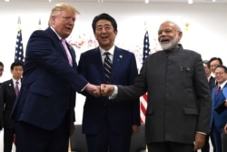 President Donald Trump, Japanese Prime Minister Shinzo Abe and Indian Prime Minister Narendra Modi share a fist bump during their meeting on the sidelines of the G-20 summit in Osaka, Japan, June 28, 2019.