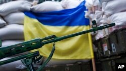 A rifle is seen in front of a Ukrainian flag in the village of Mariinka, near Donetsk, eastern Ukraine, Aug. 25, 2016.