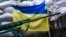 A rifle is seen in front of a Ukrainian flag in the village of Mariinka, near Donetsk, eastern Ukraine, Aug. 25, 2016.