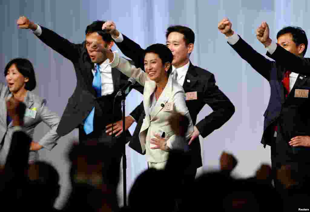 The new leader of Japan's main opposition Democratic Party, Renho (C), raises her fist along with her party lawmakers after she was elected to lead, at the party plenary meeting in Tokyo.